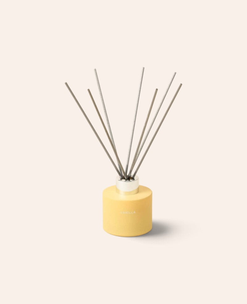 Esmée Duft Diffuser Vanilla in gelbem, mattem Glasbehälter mit sieben Holzfaser-Stäbchen für langanhaltenden Duft.