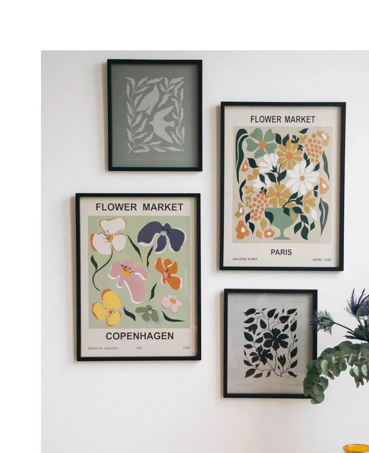 Esmée gerahmte Wandbilder mit botanischen Illustrationen und Flower Market Prints in schwarzen Rahmen an einer Wand