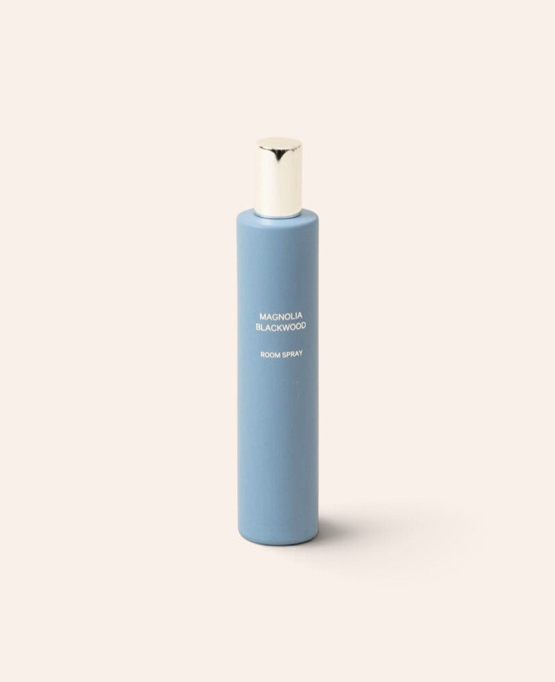 Esmée Raumspray Magnolia Blackwood in einem matten hellblauen Glasbehälter mit silbernem Verschluss.