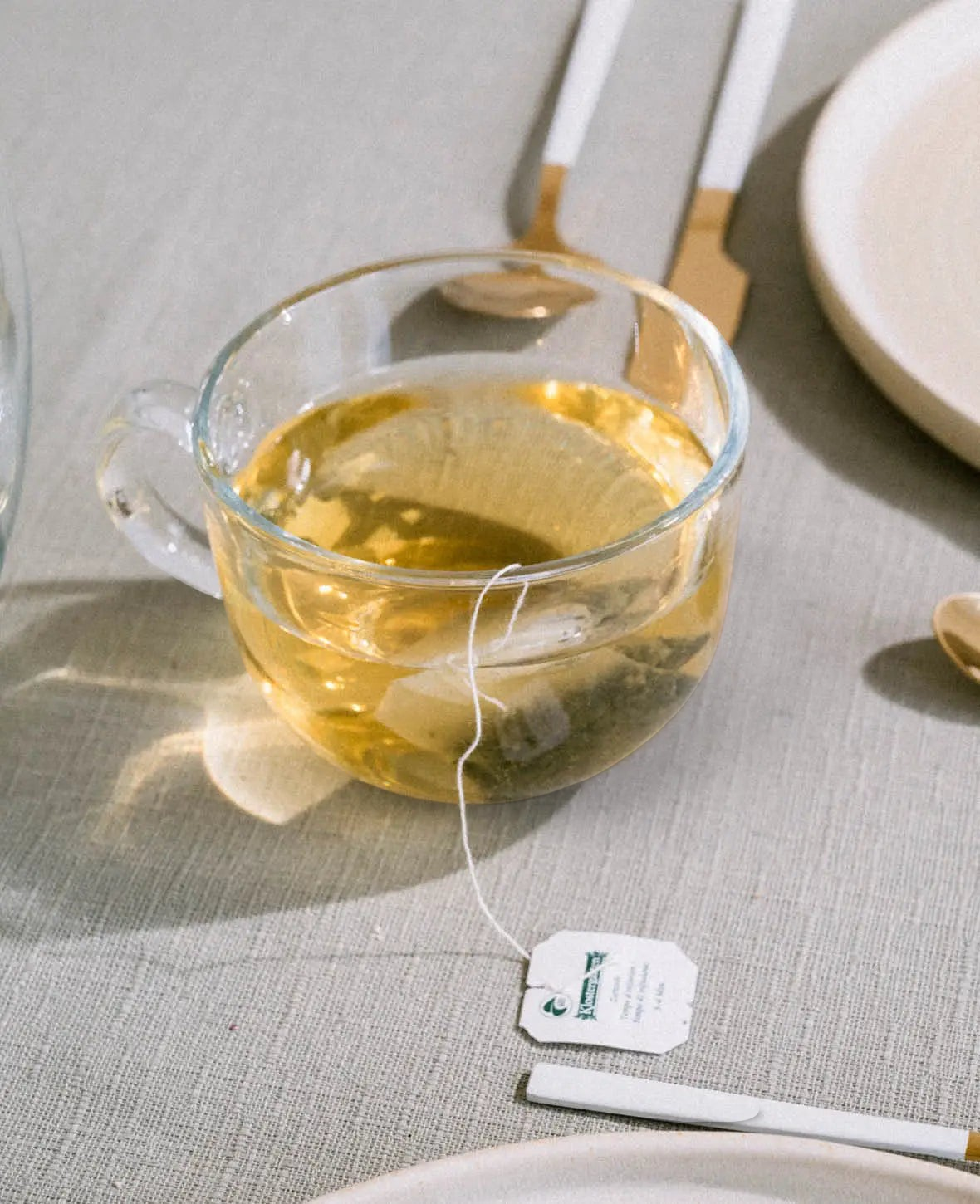 Esmée Kaffee- und Teeglas aus gehärtetem Glas mit 460 ml Fassungsvermögen und grossem Henkel auf einem Leinentisch