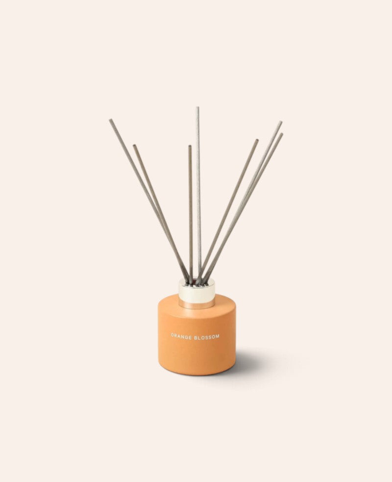 Esmée Duft Diffuser Orange Blossom in einem matten orangefarbenen Glasbehälter mit sieben Holzfaser-Stäbchen