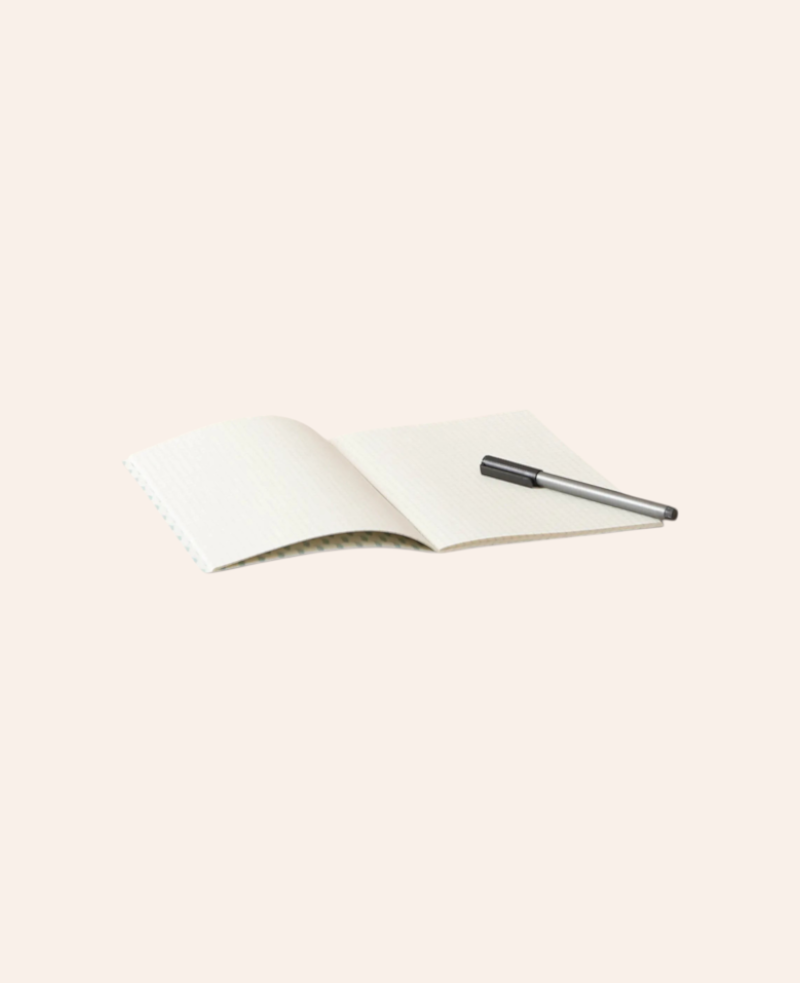 Esmée A5 Notizbuch mit Blumenmuster, 60 karierte Seiten, offen liegend mit einem Stift auf hellem Hintergrund